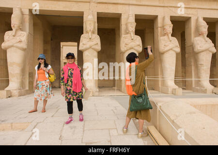 Un groupe de touristes de langue chinoise de profiter de l'expérience de visiter l'Ancien Temple égyptien d'Hatshepsout près de la Vallée des Rois, Louxor, vallée du Nil, en Égypte. Le temple funéraire de la reine Hatshepsout, le Djeser-Djeseru, est située sous les falaises de Deir el Bahari ('le Monastère du Nord'). Le temple funéraire est dédié au dieu soleil Amon-Ra et est considéré comme l'un des "monuments incomparables de l'Égypte ancienne." Le temple a été le site du massacre de 62 personnes, surtout des touristes, par les Islamistes le 17 novembre 1997. Banque D'Images