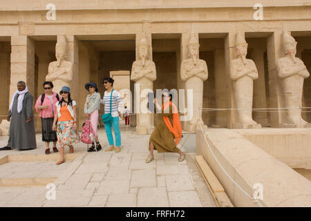 Un groupe de touristes de langue chinoise de profiter de l'expérience de visiter l'Ancien Temple égyptien d'Hatshepsout près de la Vallée des Rois, Louxor, vallée du Nil, en Égypte. Le temple funéraire de la reine Hatshepsout, le Djeser-Djeseru, est située sous les falaises de Deir el Bahari ('le Monastère du Nord'). Le temple funéraire est dédié au dieu soleil Amon-Ra et est considéré comme l'un des "monuments incomparables de l'Égypte ancienne." Le temple a été le site du massacre de 62 personnes, surtout des touristes, par les Islamistes le 17 novembre 1997. Banque D'Images