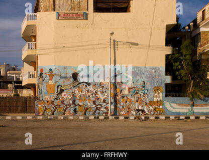 Art hiéroglyphique moderne peint sur un mur de wasteground local dans le village de Gezirat sur la rive ouest de Louxor, vallée du Nil, en Égypte. Les images montrent la bataille de Kadesh, qui a eu lieu autour de 1274 BC entre les forces de l'Empire égyptien sous Ramsès II et l'Empire hittite sous Muwatalli II à la ville de Kadès sur l'Oronte. La bataille est la première bataille de l'histoire enregistrée dont le détail de la tactique et de formations sont connus. C'était probablement la plus grande bataille jamais livrée char, impliquant peut-être 5 000-6 000 chars. Banque D'Images