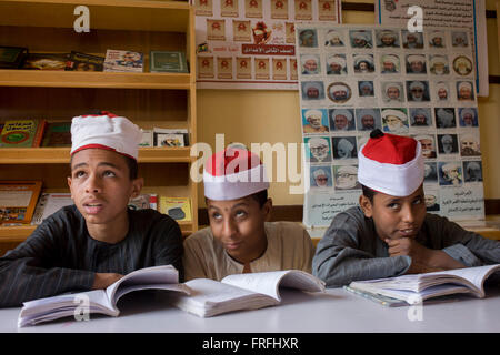 Des écoliers apprennent des versets du Coran dans une salle de classe de l'Organisation islamique al-Koom Bourit Institute pour les garçons dans le village de Qom (Koom), sur la rive ouest de Louxor, vallée du Nil, en Égypte. Banque D'Images