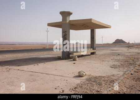 Un abri bus à distance dans un paysage désertique, près de Bagdad, Kharga Oasis, désert de l'Ouest, l'Egypte. Le désert se trouve dans la nouvelle vallée Gouvernorat, 350 km (220 mi.) et mesure environ 80 km (50 mi) d'est en ouest et 25 km (16 mi) du nord au sud et est surveillé par la police armée des convois. Banque D'Images