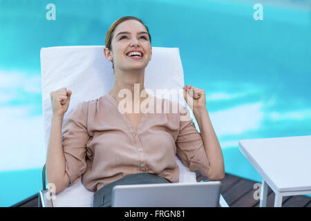 Femme excité avec piscine près de l'ordinateur portable Banque D'Images