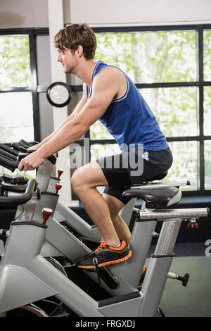 Man working out on exercise bike at spinning class Banque D'Images