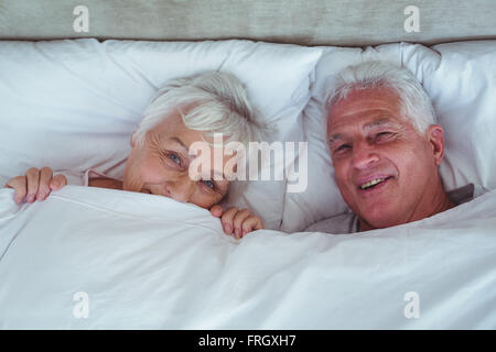 Happy senior couple lying on bed Banque D'Images