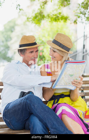 Heureux couple looking at map in park Banque D'Images
