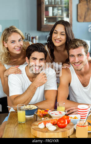 Smiling young couples à table de petit déjeuner dans la cuisine Banque D'Images