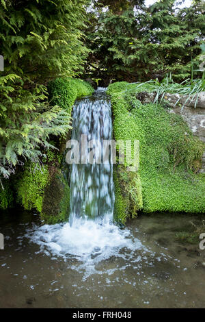 Petite cascade se jetant dans une rivière dans le joli village de lâche, Kent, UK Banque D'Images