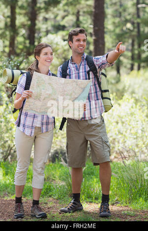 Jeune couple pointing et de planification avec la carte au cours de randonnées Banque D'Images