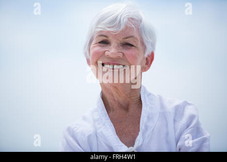 Portrait of smiling senior woman against sky Banque D'Images