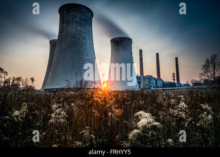 L'usine avec des tours de refroidissement de fumer dans le coucher du soleil Banque D'Images