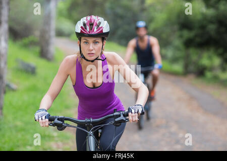 Young woman riding bike sur sentier Banque D'Images