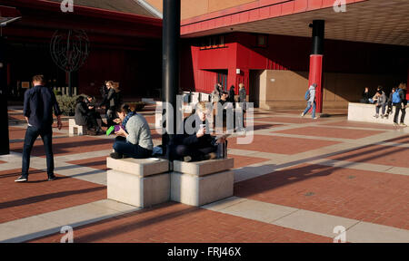 Lecture de personnes à l'extérieur sur la place à la British Library dans Euston Road London Banque D'Images