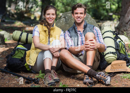 Portrait de couple sitting on rock contre champ Banque D'Images