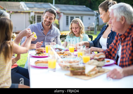 Professionnels multi-generation family eating at table Banque D'Images