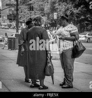 Photo candide de trois femmes afro-américaines bavardant dans la rue à New York, USA. Banque D'Images