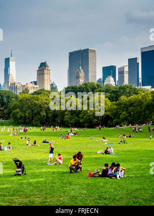 Famille relaxing on grass in Central Park, New York City, USA. Banque D'Images