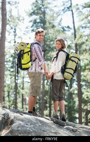 Portrait de couple holding hands and standing on rock Banque D'Images