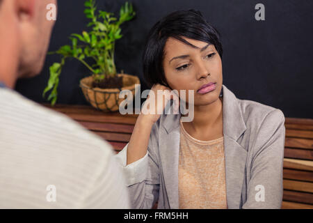 Malheureuse femme assise en face de son petit ami Banque D'Images