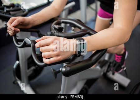 Woman on exercise bike Banque D'Images