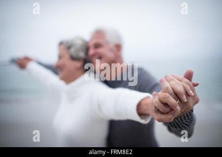 Happy senior couple standing with arms outstretched Banque D'Images