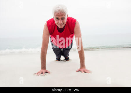 Senior man exercising on beach Banque D'Images