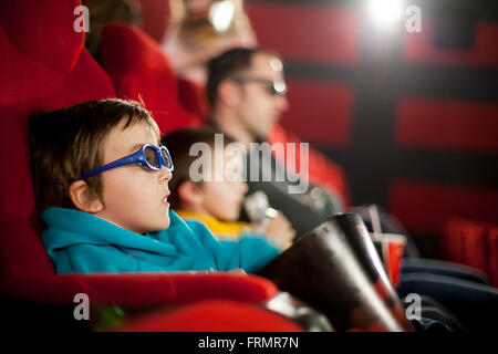 Son père et ses deux enfants, garçons, regarder cartoon movie au cinéma sur 3D Banque D'Images