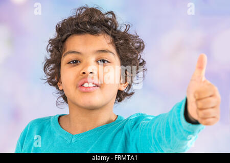 Happy boy est montrant son pouce vers le haut gauche Banque D'Images