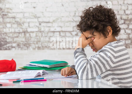 Adolescent fatigué à faire des devoirs à la maison Banque D'Images