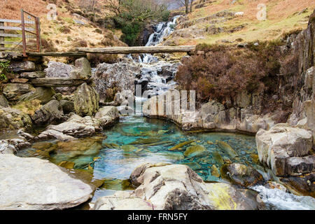 Vieille ardoise clapper bridge passerelle sur les eaux claires de la rivière Afon mcg Llançà près de Watkin Path dans le parc national de Snowdonia (Eryri). Le Nord du Pays de Galles UK Banque D'Images