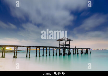 Belle Lumière du matin, de l'atterrissage en bois avec pavillon dans la mer à plage de sable noir, province de Rayong, Thaïlande. Banque D'Images