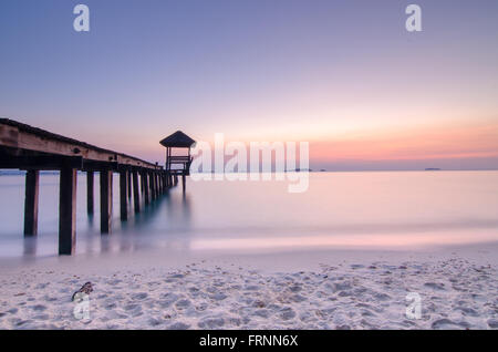 Belle Lumière du matin, de l'atterrissage en bois avec pavillon dans la mer à plage de sable noir, province de Rayong, Thaïlande. Banque D'Images