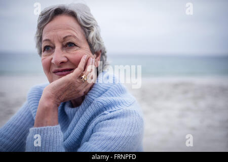 Happy homme assis sur la plage Banque D'Images