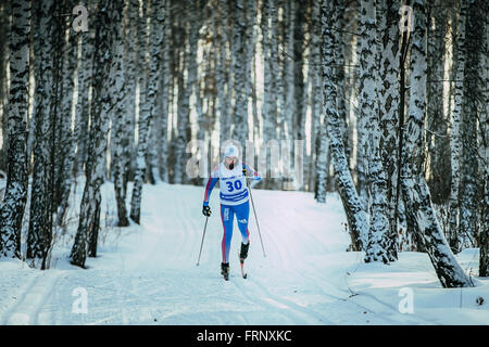 Jeune fille skieur sportif sur la voie des promenades en forêt de bouleaux dans un style classique au cours de championnat de France en ski de fond Banque D'Images