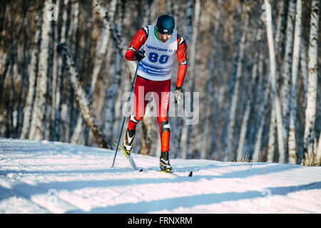 Young male skier style classique en hiver domaine skiable sur la forêt au cours de championnat de France en ski de fond Banque D'Images