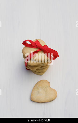 Une pile de cookies en forme de coeur attaché avec un ruban rouge. Banque D'Images