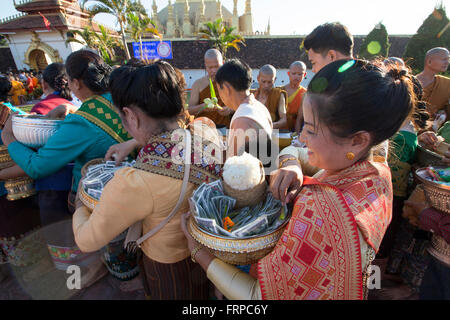 Les femmes en ligne pour donner l'aumône pendant Boun That Luang, un festival bouddhiste annuelle tenue au stupa doré (That Luang) à Vientiane, Laos. Banque D'Images