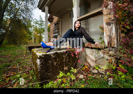 Brunette girl sitting on envahis par les escaliers. Banque D'Images