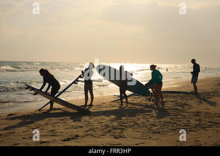 Surfers au coucher du soleil sur une plage près de Galle au Sri Lanka Banque D'Images