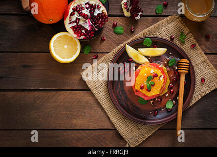 Salade de fruits avec du pamplemousse et d'orange, graines de grenade, miel et citron, décoré de menthe. Vue d'en haut Banque D'Images