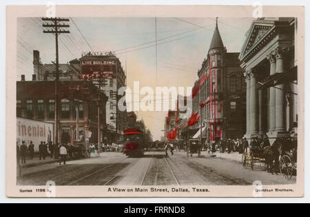 Une vraie carte postale photo (RPPC) montrant une vue de main Street à Dallas, Texas, avec diverses entreprises et immeubles de bureaux le long de la rue. L'image capture l'agitation de la vie urbaine, y compris les calèches, les chariots et l'activité de rue. Banque D'Images