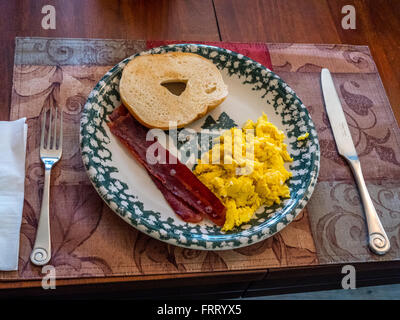 Petit-déjeuner place setting ; oeufs, bacon, bagel Banque D'Images