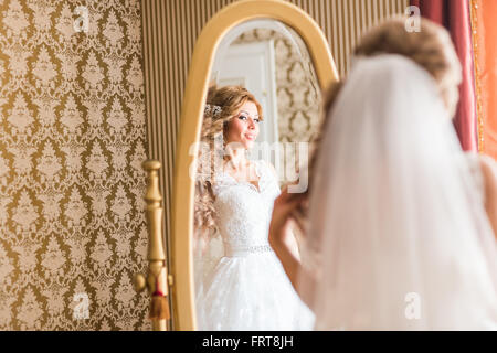 Jeune femme se regarde dans le miroir Banque D'Images