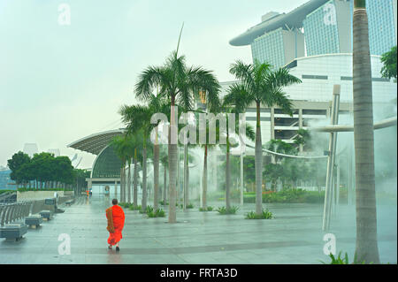 Le moine bouddhiste autour de Marina Bay Resort dans la pluie à Singapour. Banque D'Images