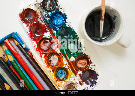 Les peintures à l'Aquarelle aquarell fort à l'aide d'un pinceau et une boîte de crayons Banque D'Images