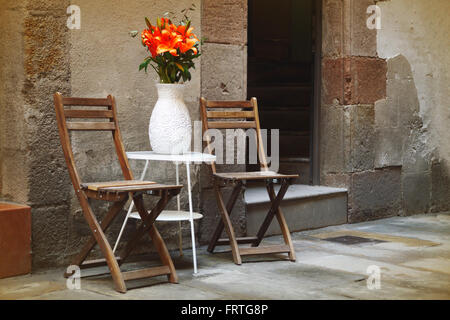 Chaises en bois rustique au milieu d'une rue à Barcelone, Espagne. Repas romantique paisible. Banque D'Images
