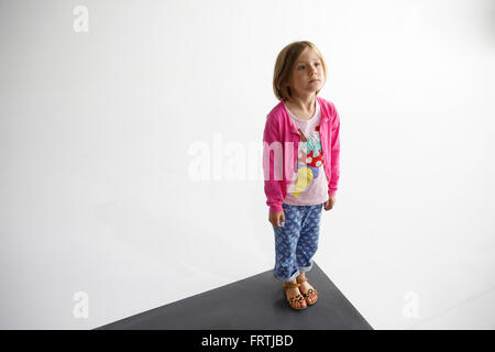 Une jeune fille pose pour une photo près d'un mur infini dans un studio photo dans la région de East London Banque D'Images