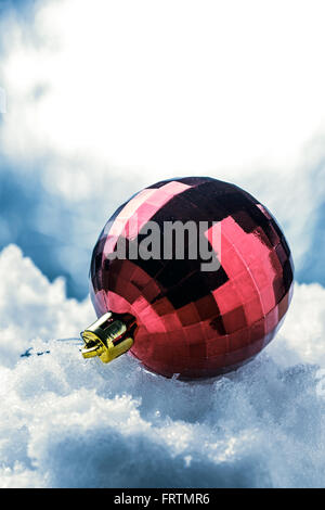 Décoration arbre de Noël Boule rouge sur la neige blanche Banque D'Images