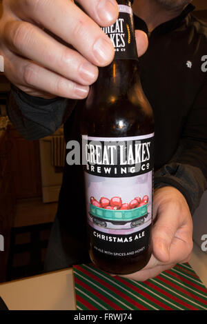 Homme tenant une bouteille de bière de Noël à Cleveland (Ohio) brassée par la Great Lakes Brewing Company. Mahtomedi Minnesota MN USA Banque D'Images