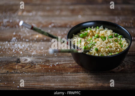 Bol de nouilles avec les pois frais et l'oignon haché. Banque D'Images