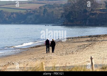 Personnes âgées en train de marcher sur une plage déserte à Studland Bay Dorset UK Banque D'Images